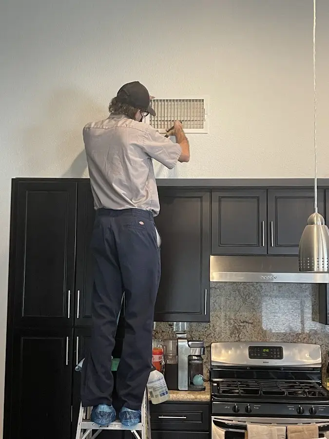 Technician inspecting an air vent during HVAC service in Rancho Murieta